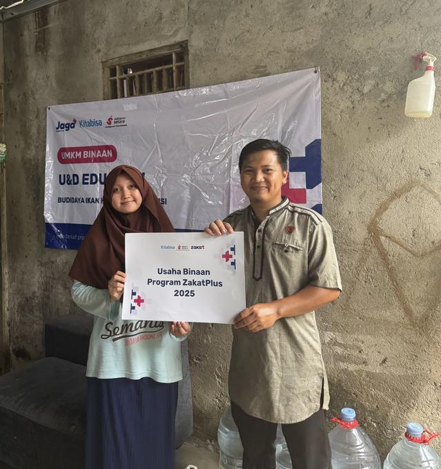 Dua penerima manfaat memegang papan Usaha Binaan Program ZakatPlus 2025